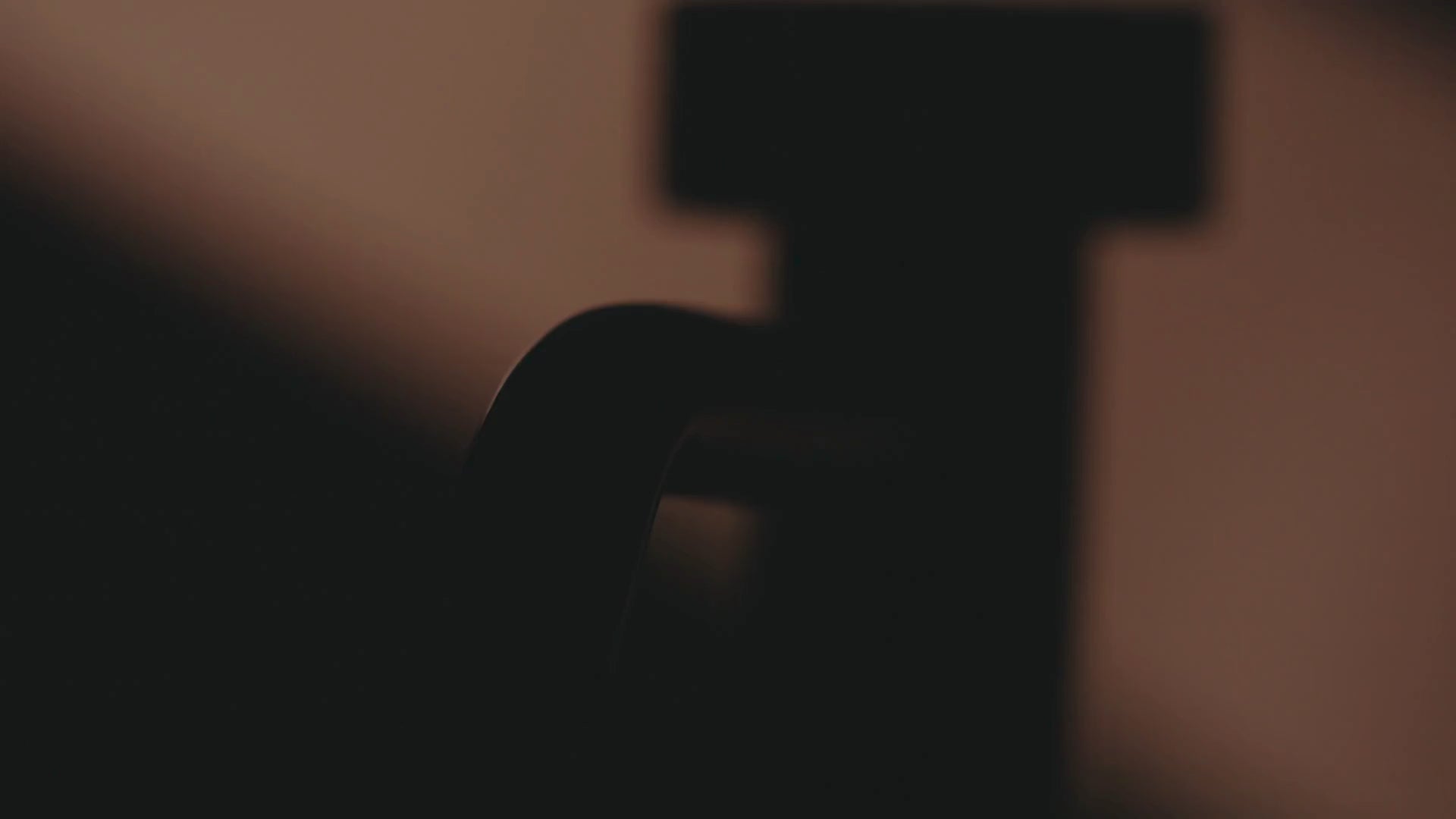 Cinematische, warm getinte silhouet-close-up van een Bongio-kraan